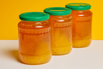 Jar of natural honey made at home on a table.