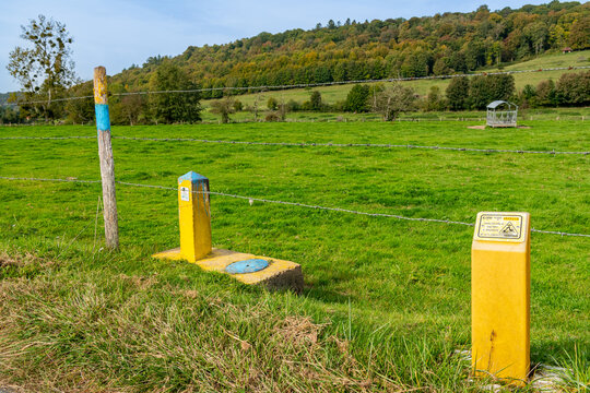 Borne de signalisation jaune et bleu de canalisation de gaz enterr&eacute;e en bordure de champ