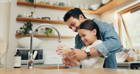 Girl washing her hands with her father in the kitchen for hygiene, health and wellness at home....