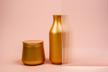 Shampoo and hair mask in a golden bottle. Air conditioner on a pink background. Hair care products....