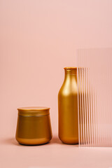 Shampoo and hair mask in a golden bottle. Hair conditioner on a pink background. Hair care products. Moisturizing and nourishing mask.