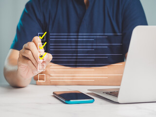 Businessman uses a pen to tick the correct sign mark for a quality document control checklist, and...