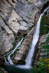 turquoise crystal clear water of a waterfall of a mountain Alpine river