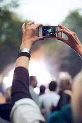 Hands, cellphone and picture at music concert in crowd for social media post for holiday, carnival or celebration. Person, photography and summer event for travel party or forest, camping or festival