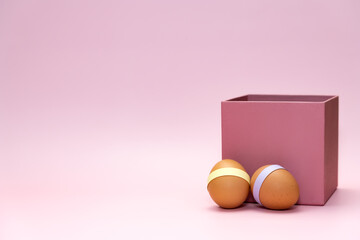 Easter eggs in front of pink square box on empty background