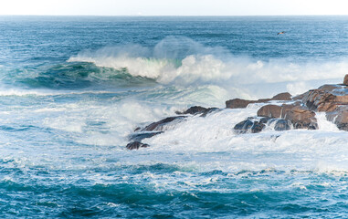 Panoramic view of violent waves crashing against the rocks of the Galician coast (Spain) during a storm.