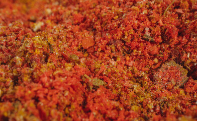 Assorted seasonings in a pile. Background of red paprika powder. Close up of red paprika in a spice shop, texture.