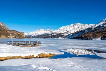 Engadine, Switzerland, Sils Maria lake, the village of Isola and the snowy landscape.
