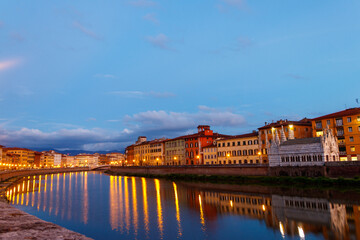 Panoramic view of the old town of Pisa and the Arno river at twilight, Italy. Night cityscape - obrazy, fototapety, plakaty