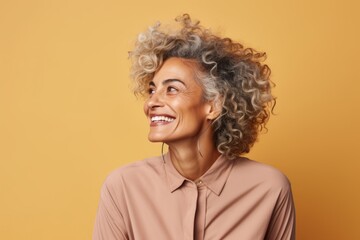 Fototapeta na wymiar Portrait of smiling african american woman with curly hair on yellow background