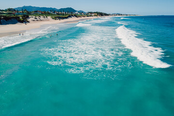 Holiday beach and ocean with waves in Floripa. Aerial view of Morro das Pedras