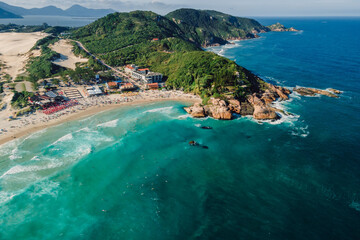 Popular holiday beach with cape and ocean with waves in Brazil. Aerial view