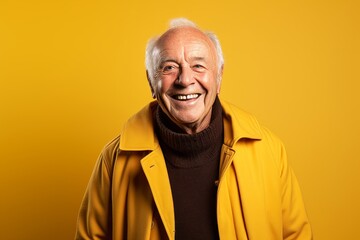Portrait of a happy senior man on a yellow background. Elderly people concept.