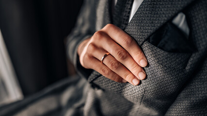 Close-up of a groom getting ready for his wedding day. Wedding ring, groom's hand close up - obrazy, fototapety, plakaty