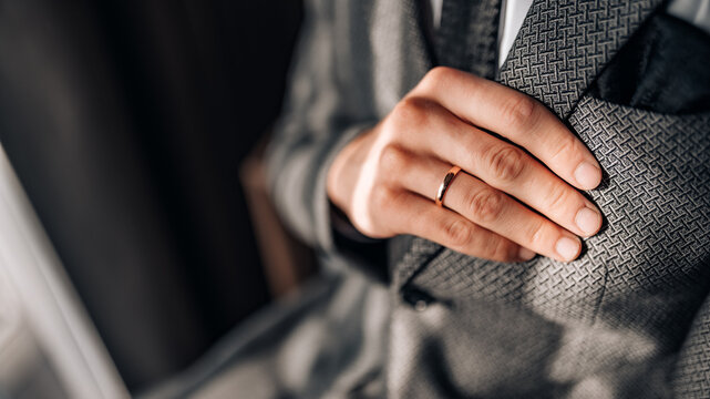 Close-up of a groom getting ready for his wedding day. Wedding ring, groom's hand close up