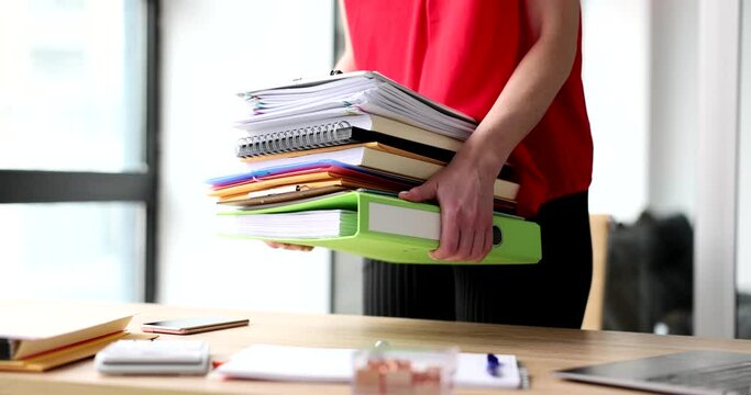 Female hands of trainee secretary hold stack of folders and documents. Overtime work time management and internship in company