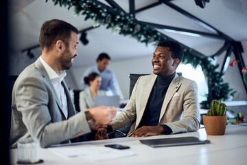Two business male colleagues, talking and laughing at the office.