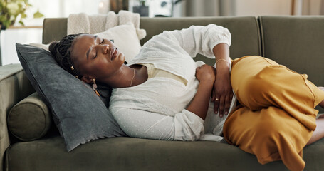 Home, pain and black woman on a couch, cramps and stomach with sickness, suffering and disease in the living room. African person, apartment and girl with abdominal problem, tummy ache and period - obrazy, fototapety, plakaty