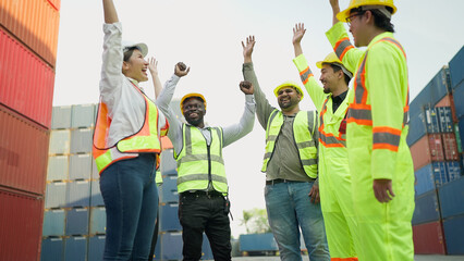 Multiracial team of engineer and foreman in hardhat and safety uniform cheering to celebrate after...