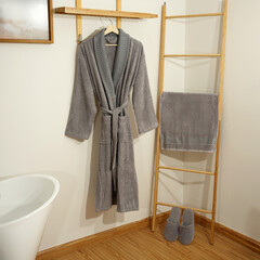 Bathrobe set - Hanger with clean bathrobe and towel on light wall bathrobe mockup