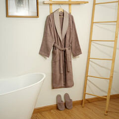 Bathrobe set - Hanger with clean bathrobe and towel on light wall bathrobe mockup