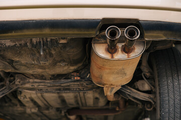 under car exhaust pipe muffler old aged rust rusty closeup auto part service