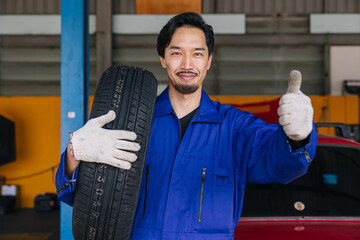Asian Japanese male mechanic worker portrait in auto service workshop car tyre maintenance center replace fix auto part