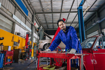 Fototapeta na wymiar Portrait Asian Japanese male mechanic worker portrait in auto service workshop car maintenance center replace fix auto engine part