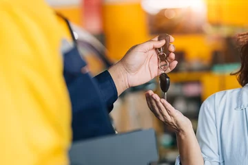  Mechanic car dealer giving car key to customer for finished car service fix problem or auto sell deal © Quality Stock Arts