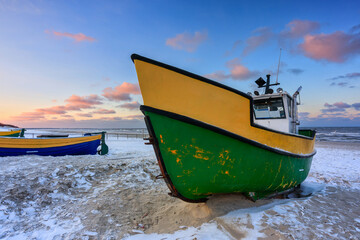 Fototapeta premium Fishing boats on the Baltic Sea beach in Jantar at winter. Poland