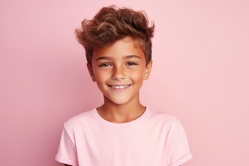 Portrait of a cute little boy smiling and looking at camera over pink background - obrazy, fototapety, plakaty