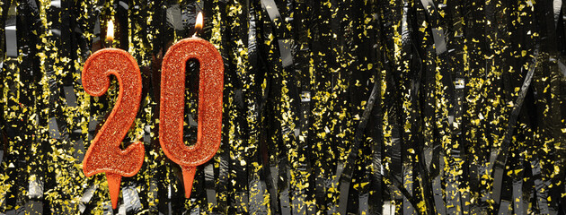 Burning red birthday candles on glitter tinsel background, number 20. Banner.