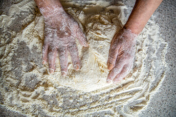 Old woman hands - process the dough for wheat bread. Preparation doughs. Preparation doughs women's hands. Making dough by male hands at bakery. Food concept. Hands dough