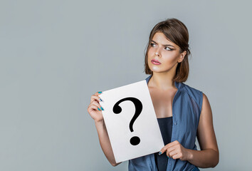 Woman holding a placard with question mark symbol, thinking. Girl question. Woman with doubtful...