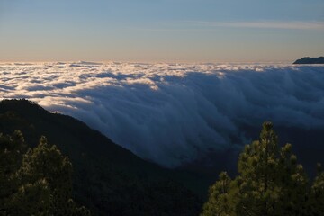 Sunrise in mountains with inversion phenomenon and low clouds lit by sun. Refugio Punta de Los...