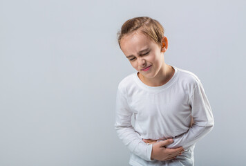 Child has stomachache with food poisoning. Child holding hands on belly. Stomach pain. Teen boy with stomachache. Child having terrible pain in stomach. Diarrhea or gastroenteritis health problem