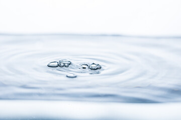 Playful bubbles dancing on the water's surface against a pristine white backdrop. Perfect for...