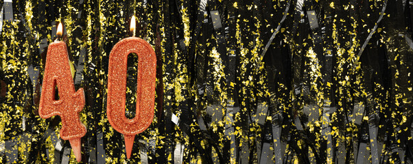 Burning red birthday candles on glitter tinsel background, number 40. Banner.