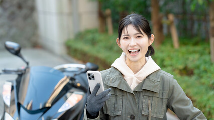 スマホを持つバイク女子