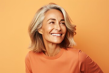 Portrait of happy mature woman looking up, over yellow background.