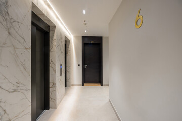 Interior of a corridor with apartment doors and marble wall