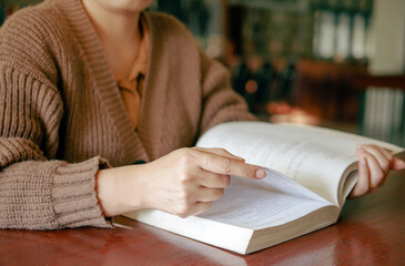 Learning, education Hand of Senior woman sitting   reading fiction book on wooden table,relax and...