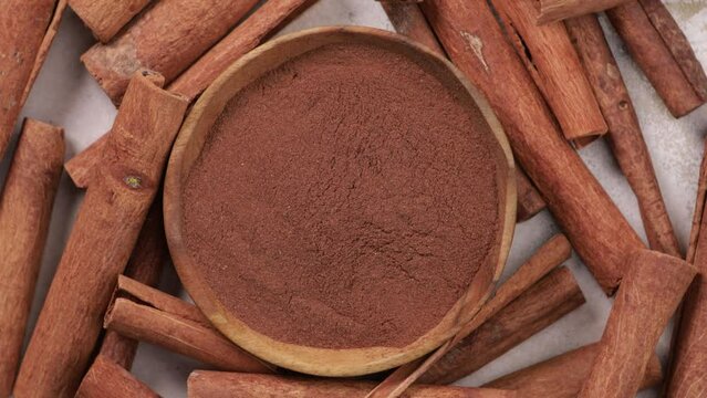 cinnamon powder and sticks in bowl top view