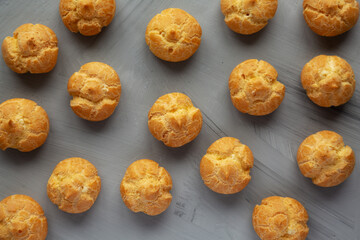 Homemade Mini Cream Puffs on a gray background, top view.