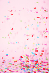 festive confetti in front of a colorful pink rose background
