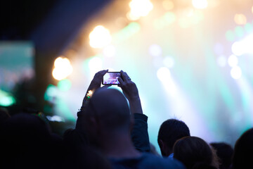 Hands, cellphone and photography at music concert in crowd for social media post for holiday,...