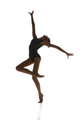 Full-length image of talented, artistic teen girl, rhythmic gymnast in stage costume performing against white studio background. Concept of sport, beauty and grace, competition, art, youth, hobby