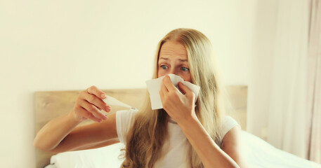 Sick woman sneezing blow nose using tissue measuring checking body temperature with thermometer