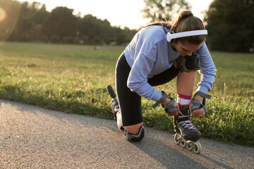 Woman preparing to rollerblade in the park