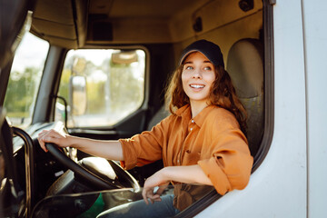 Female driver looking out of truck window. Transport industry theme